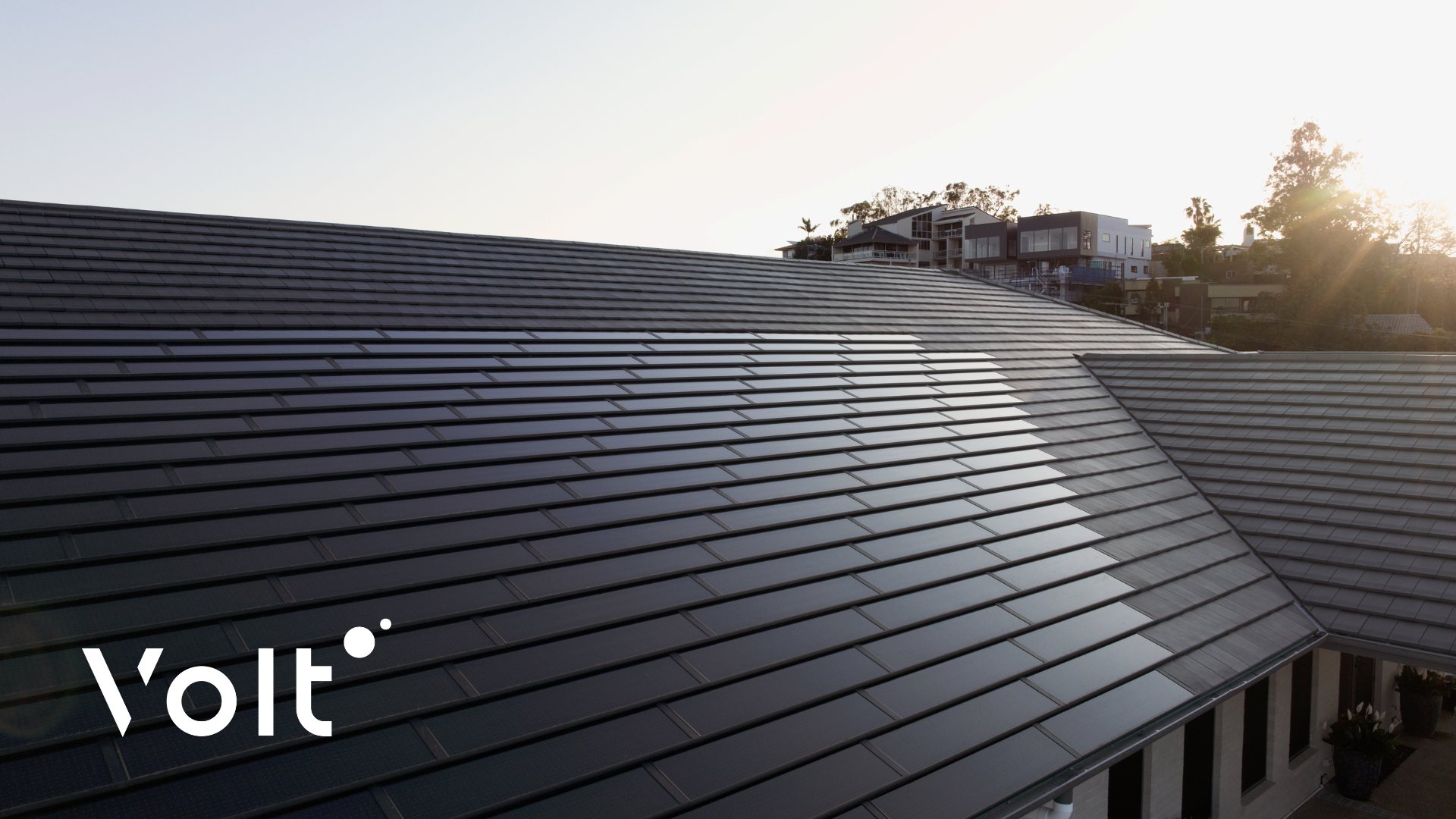 Close-up of a large gable roof fitted with Volt integrated solar roof tiles, showing a seamless tiled array on a modern home at sunset.
