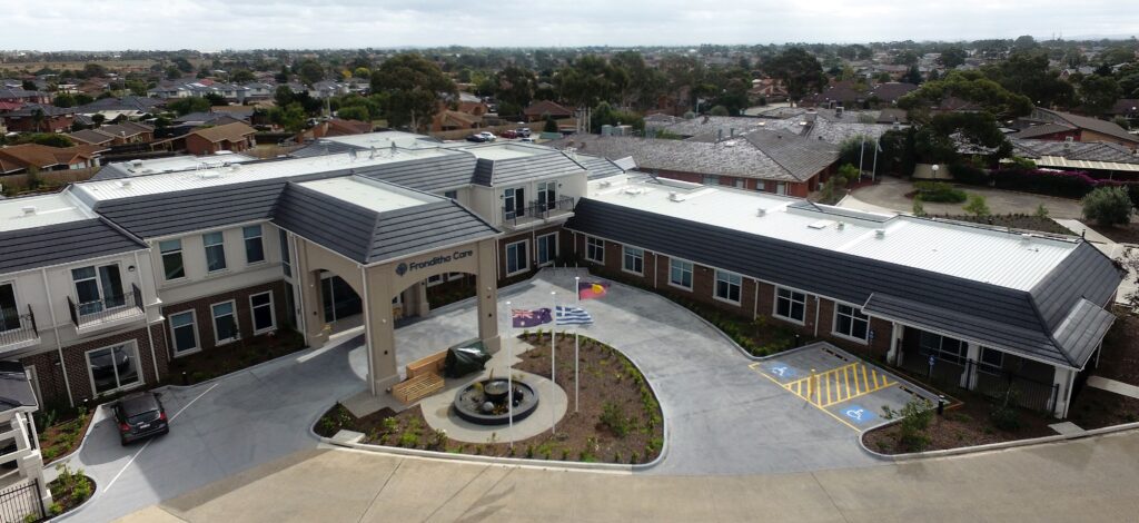 Commercial roof replacement completed on a large aged care facility in Australia, featuring new metal roofing and tiled parapets.