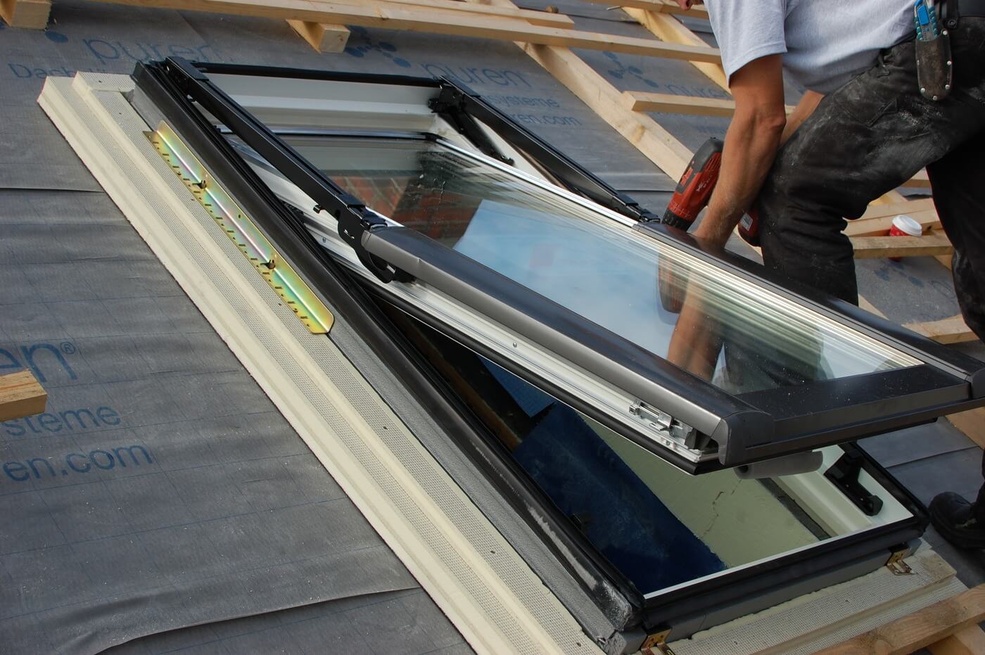 Newcastle skylight installation in progress, showing a technician fitting a modern roof window into a timber-framed roof.
