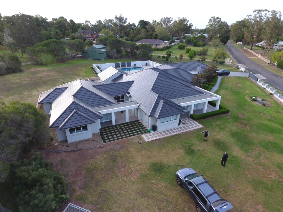 Aerial view of a Sydney home with a restored tiled roof after professional roof restoration service