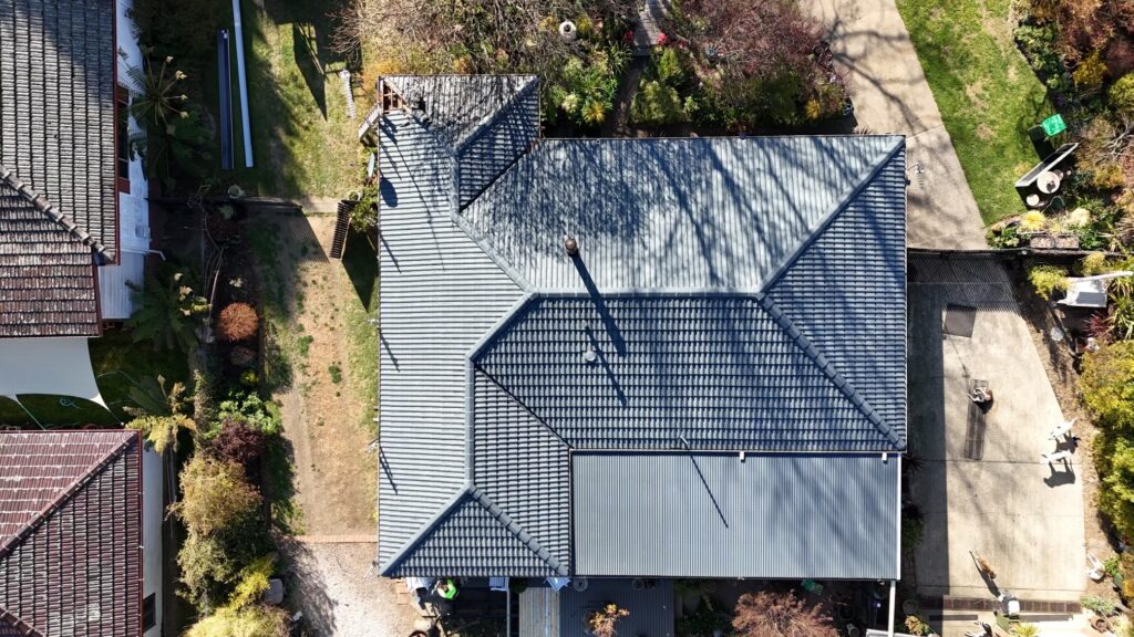 Aerial view of tile roof repair on a Sydney home showing restored sections and repaired roof tiles.